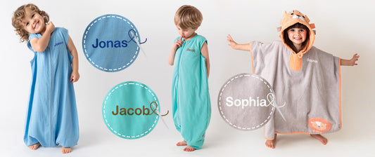 Drei Kinder in personalisierten Schlafsäcken mit Füßen mit den Namen Jonas, Jacob und Sophia posieren fröhlich.