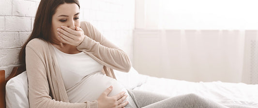 Schwangere Frau, die an Übelkeit leidet und ihren Mund hält.